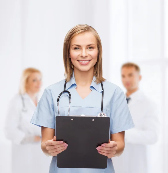 Médico o enfermera sonriente con portapapeles —  Fotos de Stock