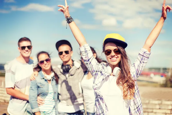 Adolescente chica con auriculares y amigos fuera — Foto de Stock