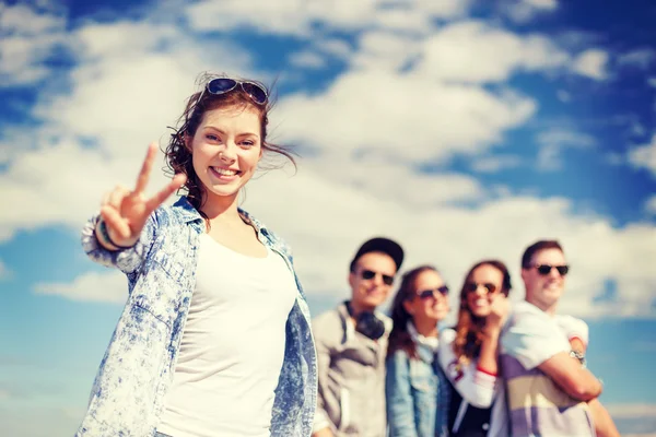 Teenage girl with headphones and friends outside — Stock Photo, Image