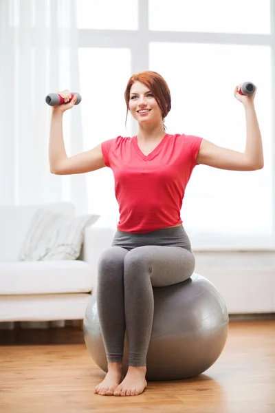 Lächelndes rothaariges Mädchen, das mit Fitnessball trainiert — Stockfoto