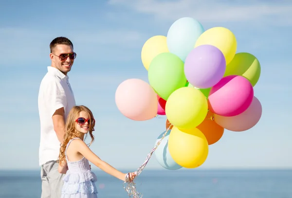 Glücklicher Vater und Tochter mit bunten Luftballons — Stockfoto