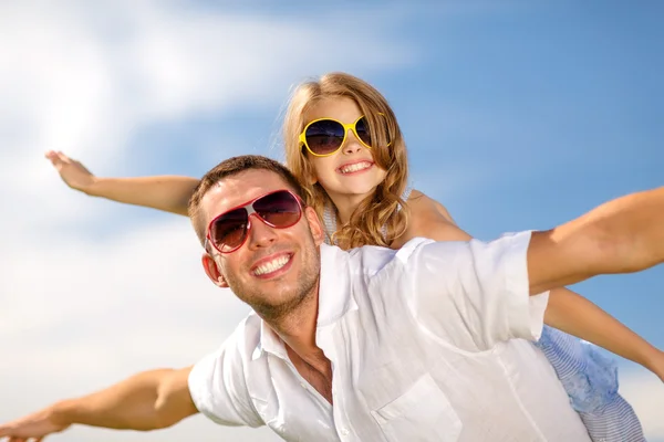 Gelukkig vader en kind in zonnebril over blauwe hemel — Stockfoto