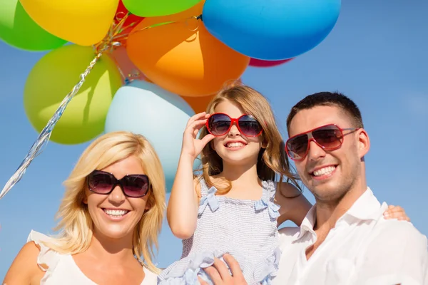 Ευτυχισμένη οικογένεια με πολύχρωμα μπαλόνια σε εξωτερικούς χώρους — Φωτογραφία Αρχείου