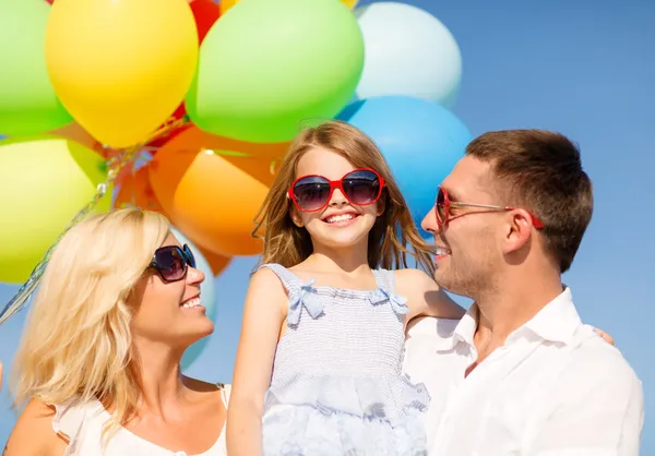 Gelukkige familie met kleurrijke ballonnen buitenshuis — Stockfoto