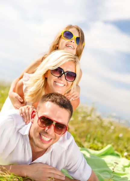 Lächelnde Familie mit Sonnenbrille auf Decke liegend — Stockfoto