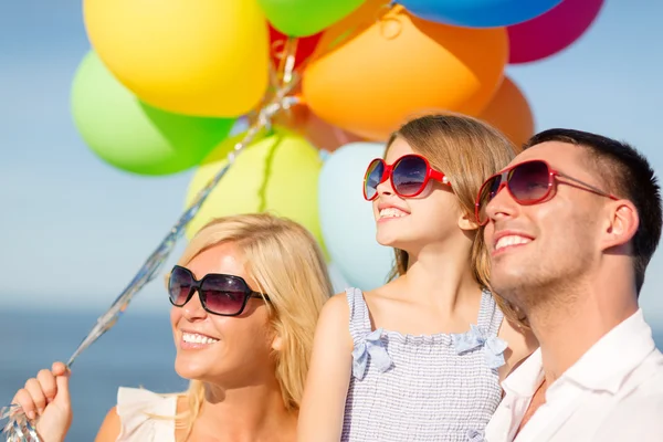 Šťastná rodina s barevnými balónky venku — Stock fotografie