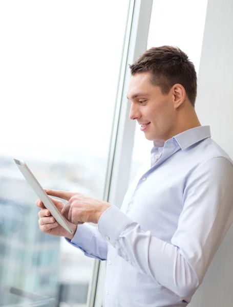 Sonriente hombre de negocios con tablet pc en la oficina — Foto de Stock