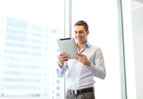 Sonriente hombre de negocios con tablet pc en la oficina —  Fotos de Stock