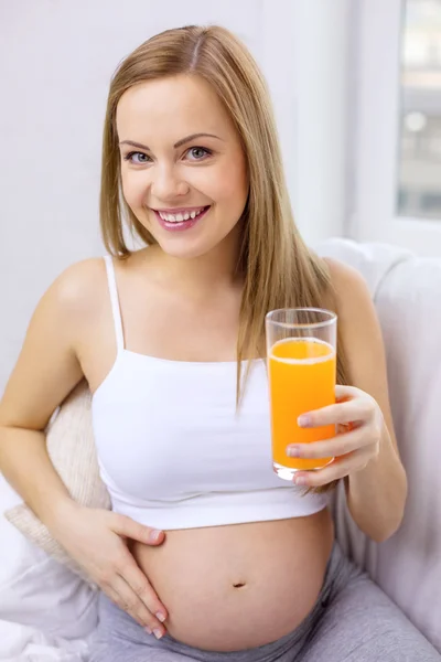 Mujer embarazada feliz con jugo de naranja fresco —  Fotos de Stock