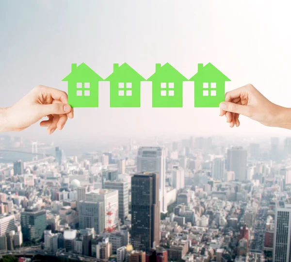 Man and woman hands with many green paper houses — Stock Photo, Image