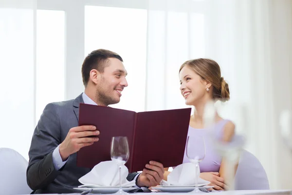 Casal sorridente com menu no restaurante — Fotografia de Stock