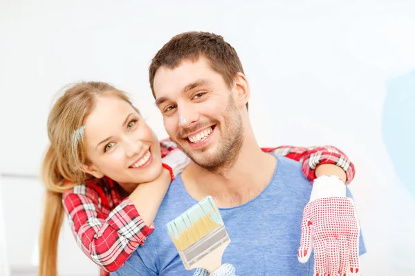 Casal sorridente coberto com tinta com pincel — Fotografia de Stock