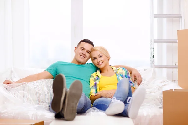 Улыбающаяся пара отдыхает на диване в новом доме — стоковое фото