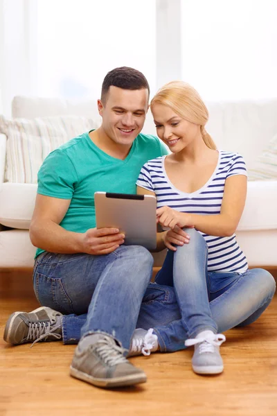 Uśmiechający się szczęśliwa para z komputera typu tablet w domu — Zdjęcie stockowe