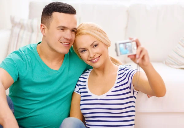 Sonriente pareja tomando fotos con cámara digital — Foto de Stock