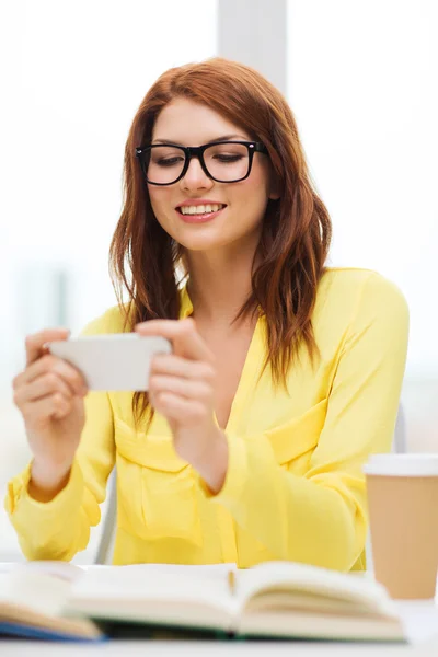 Studentessa sorridente con smartphone a scuola — Foto Stock