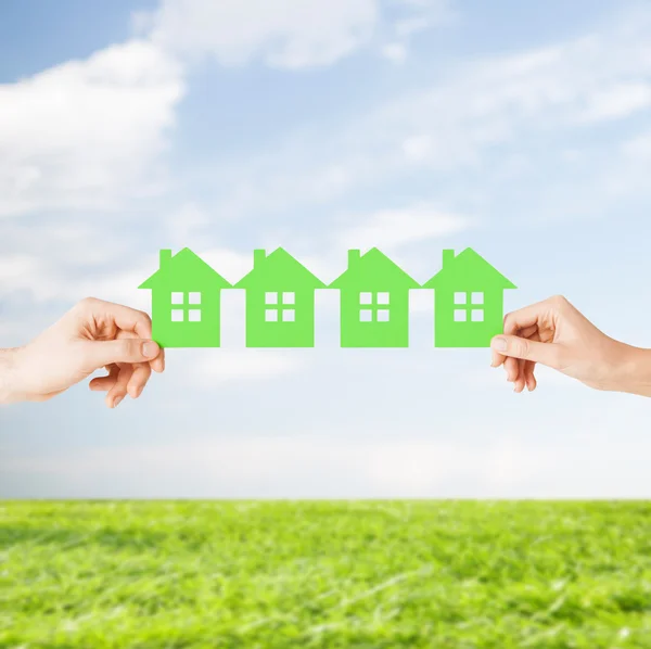 Man and woman hands with many green paper houses — Stock Photo, Image