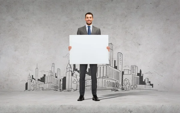 Smiling businessman with white blank board — Stock Photo, Image