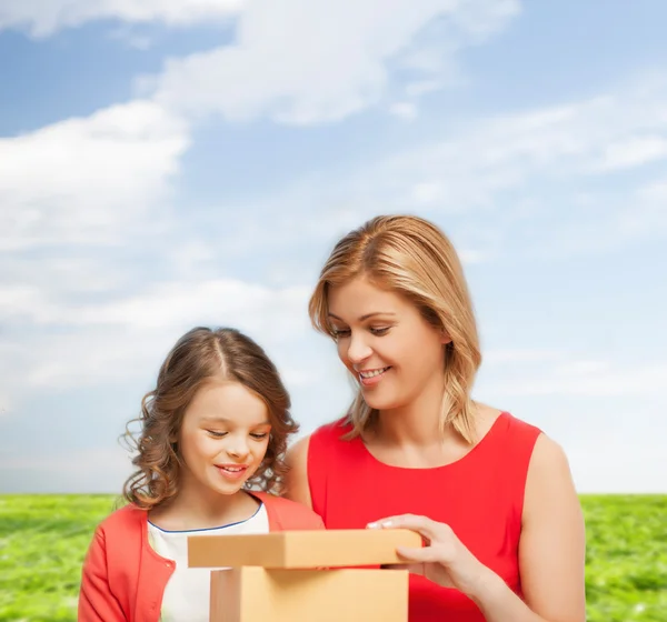 Sorrindo mãe e filha com caixa de presente — Fotografia de Stock