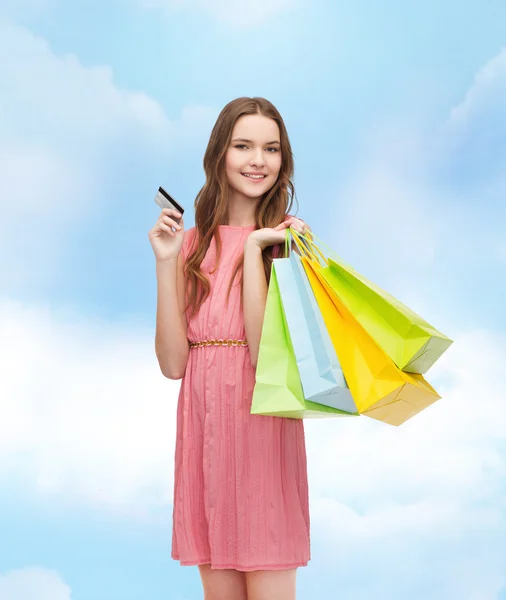 Mulher sorridente em vestido com muitos sacos de compras — Fotografia de Stock
