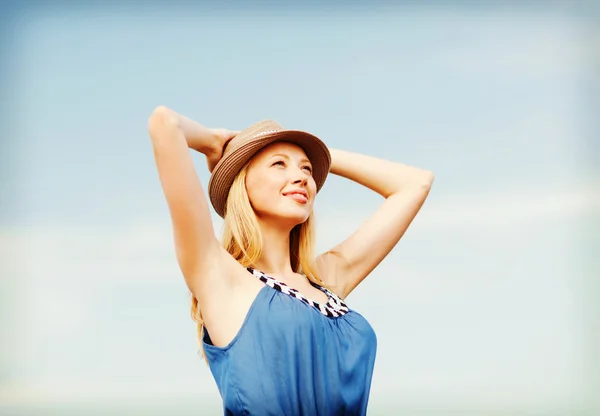 Meisje in hoed staande op het strand — Stockfoto