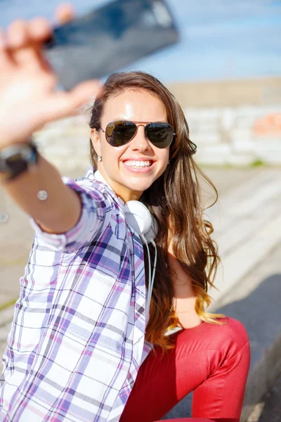 Lachende tiener nemen van foto met smartphone — Stockfoto