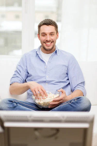 Smiling man watching sports at home — Stock Photo, Image
