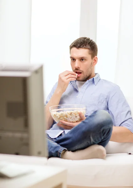 Glimlachende man kijken naar sport thuis — Stockfoto