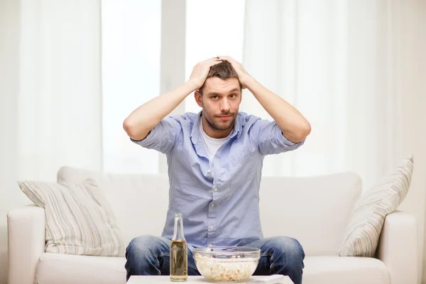 Verdrietig man kijken naar sport thuis — Stockfoto