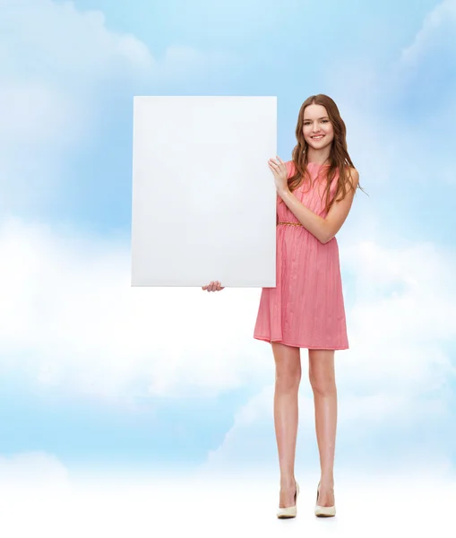 Jonge vrouw in jurk met wit leeg bord Stockfoto