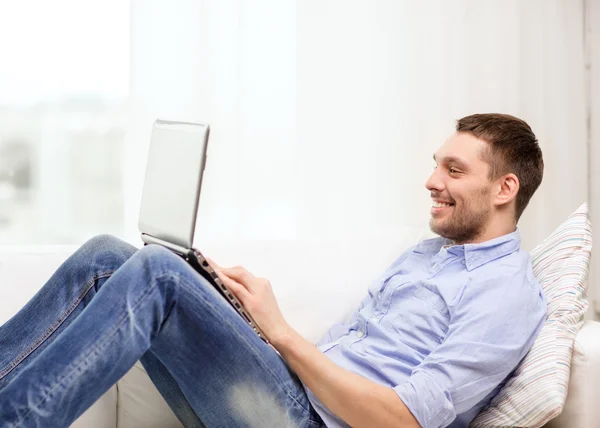 Gülümseyen adam evde laptop ile çalışma - Stok İmaj