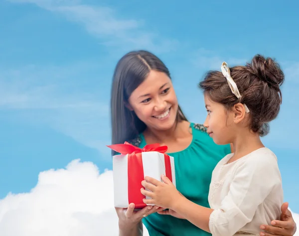 Щаслива мати і дівчинка з подарунковою коробкою — стокове фото