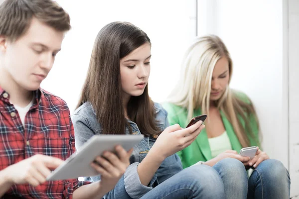 Studenti při pohledu do zařízení ve škole — Stock fotografie