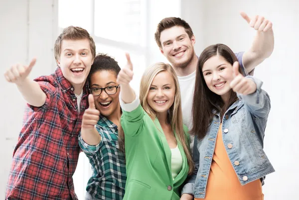 Estudiantes mostrando pulgares en la escuela — Foto de Stock