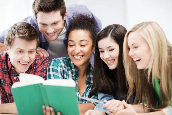 Estudiantes leyendo libro en la escuela — Foto de Stock