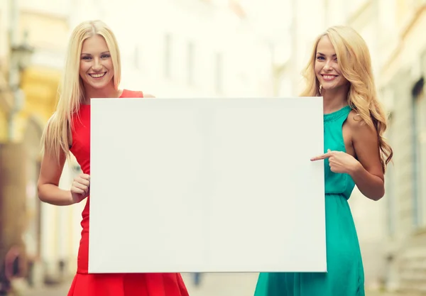 Dos mujeres rubias felices con pizarra blanca en blanco —  Fotos de Stock