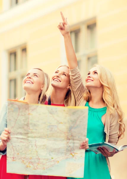 Hermosas mujeres con mapa turístico en la ciudad — Foto de Stock