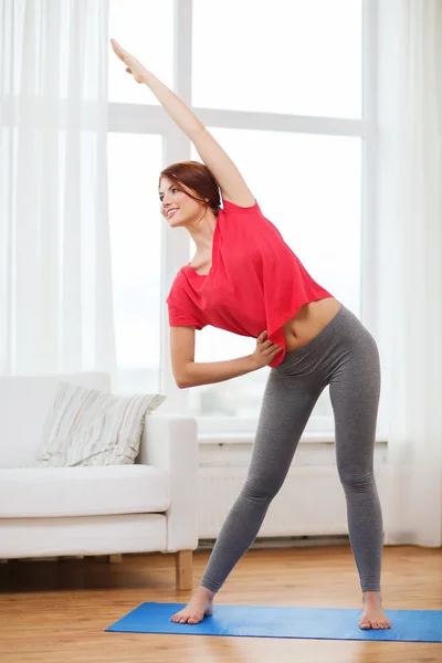 Smiling teenage girl streching at home — Stock Photo, Image