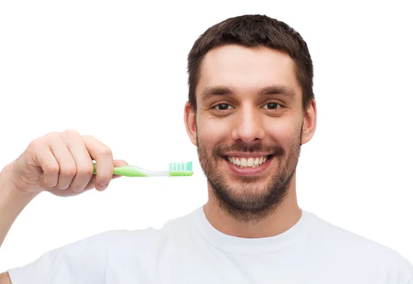 Jeune homme souriant avec brosse à dents — Photo