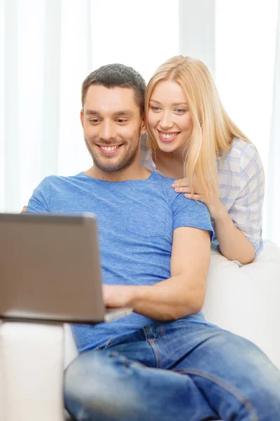 Χαμογελαστό ευτυχισμένο ζευγάρι με φορητό υπολογιστή στο σπίτι — Φωτογραφία Αρχείου