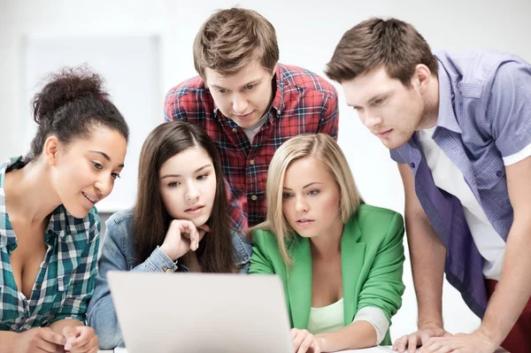 Estudiantes internacionales mirando el portátil en la escuela Imágenes De Stock Sin Royalties Gratis