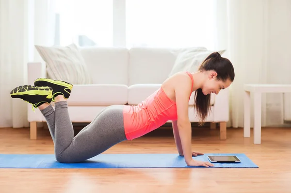 Smiling teenage girl doing push-ups at home — Stock Photo, Image