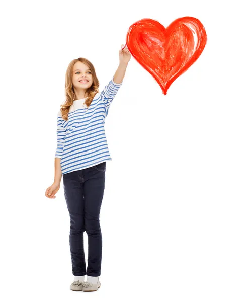 Girl drawing big red heart in the air — Stock Photo, Image