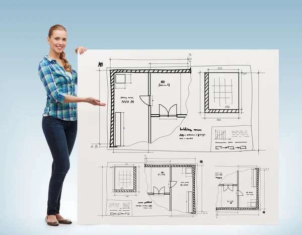 Smiling young woman with white board and blueprint — Stock Photo, Image