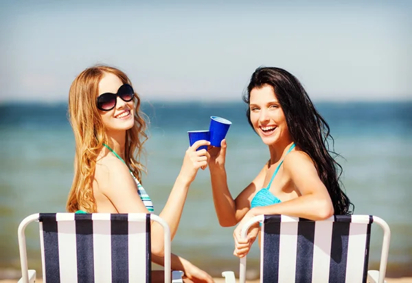 Girls with drinks on the beach chairs — Stock Photo, Image