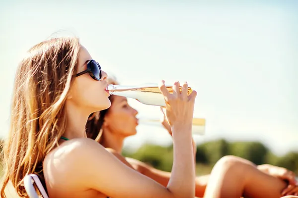 Meisjes met dranken op de strandstoelen — Stockfoto
