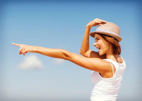 Ragazza in cappello che mostra la direzione sulla spiaggia — Foto Stock