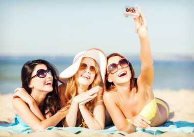 Girls taking self photo on the beach clipart