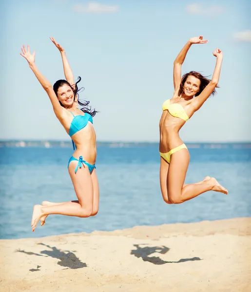 Mädchen im Bikini springen am Strand — Stockfoto