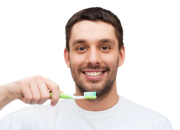 Улыбающийся молодой человек с зубной щеткой — стоковое фото